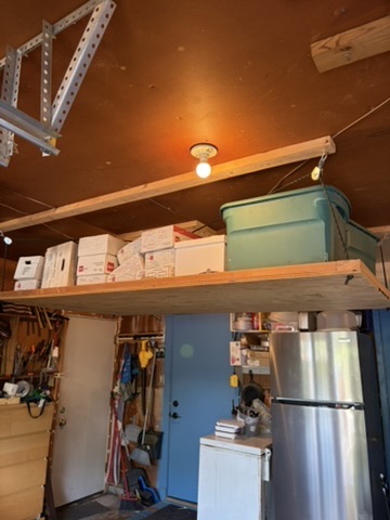 Winch-powered garage storage platform holding storage bins above a garage floor