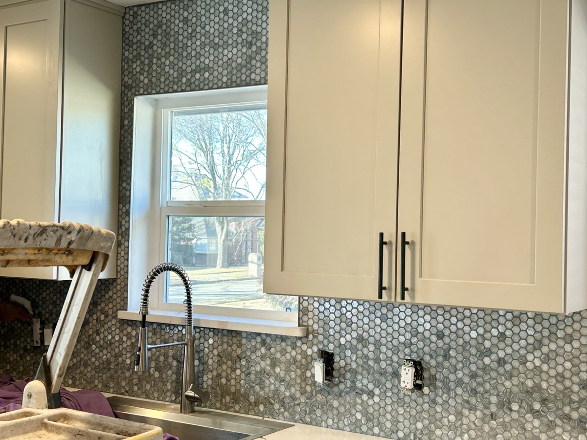 Kitchen backsplash installation around a window
