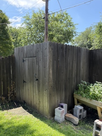 Custom wood shed enclosure and gate in a backyard